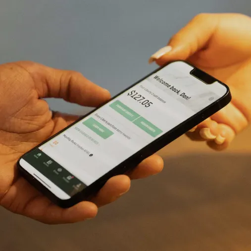 Hands holding a phone featuring Liberty Wallet app
