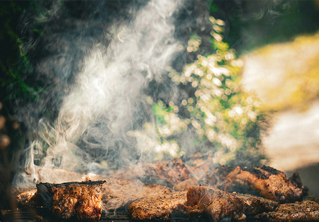 A close up of a grill with food cooking on it