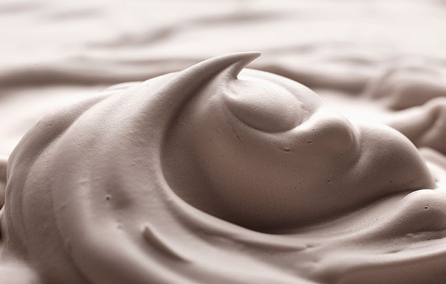 Close-up image of white frosting, emphasizing its soft texture and smooth surface.